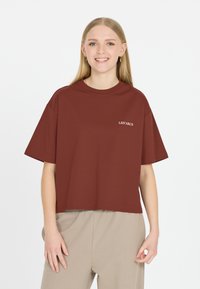 Mörkröd kortärmad t-shirt med ribbad rund halsringning, har vit text "LES'ARCS" på vänster sida. Slät tygtextur.