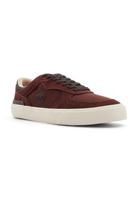 Sneaker in suede bordeaux con dettagli beige, punta arrotondata, lacci marroni e logo laterale. Suola in gomma bianca spessa.