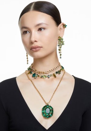 Grün-goldenes Schmuckset mit geschichteten Halsketten, großem Smaragd-Anhänger und Kronleuchter-Ohrringen mit verschiedenen Formen und Texturen.