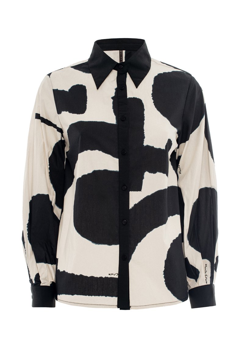 Long-sleeve shirt in beige with large black abstract patterns. Features a pointed collar and button-down front with black buttons.
