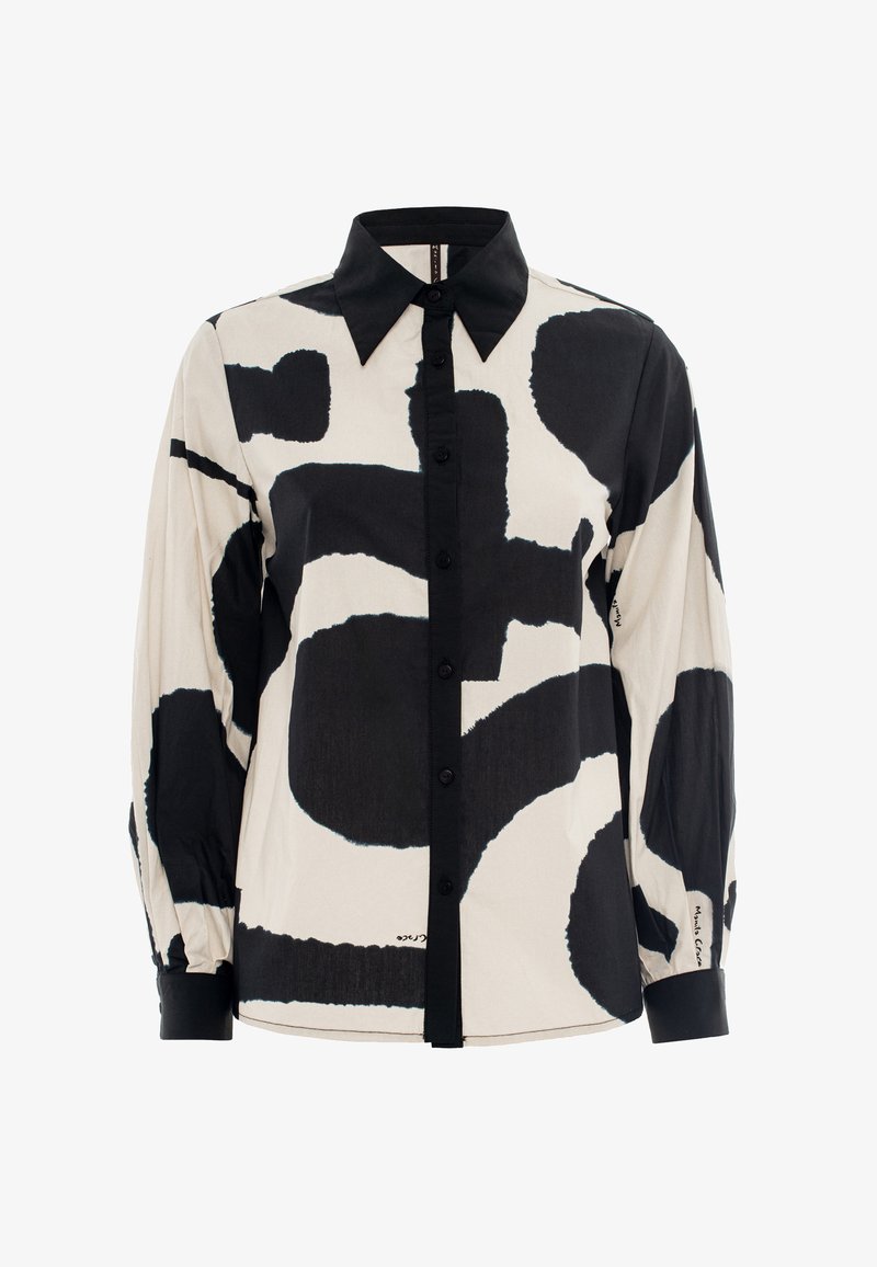 Long-sleeve shirt in beige with large black abstract patterns. Features a pointed collar and button-down front with black buttons.