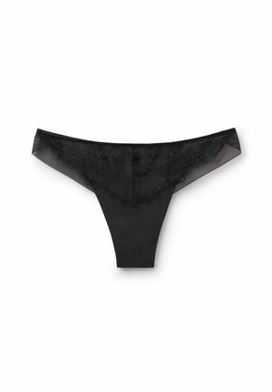 Zwarte stringonderbroek met een kanten voorpaneel, doorzichtige zijkanten en een gladde achterkant. Bevat delicate bloemenpatronen op de kanten rand.