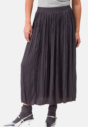 Gonnona midi plissettata grigio scuro con vita elastica, abbinata a scarpe con tacco argentate e calze grigie a coste. Tessuto leggero con texture.