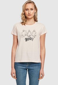 Šviesiai rožinė medvilninė marškinė su apvaliu iškirpimu, trumpomis rankovėmis ir grafika, kurioje pavaizduoti trys vaiduokliai virš juodo teksto "BOO!".