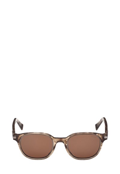 Occhiali da sole con montatura in plastica trasparente e marmorizzata marrone, lenti rettangolari e dettagli testurizzati sulle aste. Le lenti marroni sfumate offrono protezione UV.