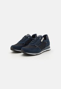 Sneaker blu navy con un mix di materiali lisci e testurizzati, con design a lacci, zip laterale e suola bianca a contrasto.