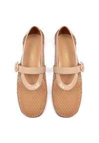 Chaussures Mary Jane en cuir verni couleur nude, avec un corps en maille tissée et un bout rond. Elles comportent une bride à boucle et une semelle intérieure à texture lisse.