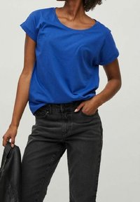 Modré tričko s krátkým rukávem z bavlněného materiálu, s kulatým výstřihem a pohodlným střihem, spojené s černými džíny pro ležérní vzhled.