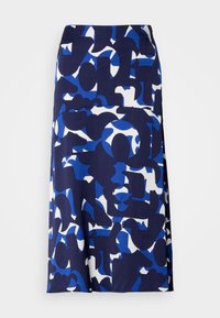 Jupe midi bleue et blanche avec des formes géométriques abstraites et irrégulières dans des tons de bleu foncé et clair sur fond blanc.
