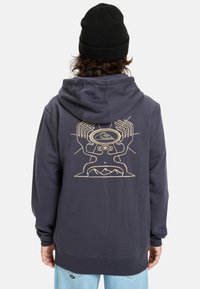 Hooded sweatshirt in dark gray cotton features a front kangaroo pocket, ribbed cuffs, and a gold graphic design on the back.