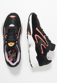 Svarta sneakers med korallfärgade detaljer; de har material av mocka och mesh, en tjock sula och ett vadderat innertyg. Inkluderar logodetalj på tungan.