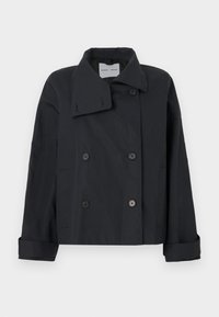 Chaqueta negra de doble botonadura con un gran cuello, hecha de tejido suave. Presenta detalles de botones y puños enrollados. Diseño minimalista.