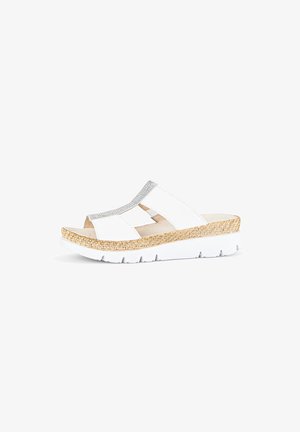 Witte slide-sandalen met een gestructureerde bovenzijde, een zilveren accentstrook en een geweven patroon op een lichtbruine platformzool. Lichtgewicht ontwerp.