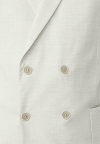 Lichtgrijze dubbelzijdige blazer van een gestructureerde stof, met twee beige knopen en een gekleed kraag, voorzien van subtiele stikdetails.