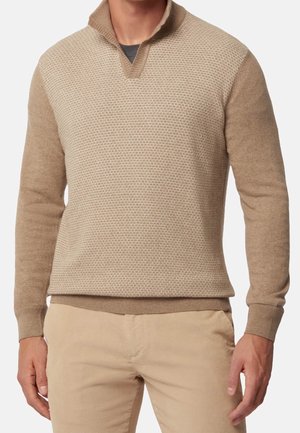 Beige Pullover mit einem strukturierten, gemusterten Vorderteil und einfarbigen Ärmeln. Er hat einen schlichten Kragen und gerippte Bündchen und besteht aus einem weichen Material.