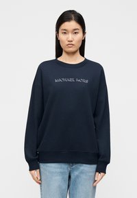 Μπλε σκούρο φούτερ από απαλό ύφασμα, με στρογγυλή λαιμόκοψη και χαμηλωμένους ώμους. Λογότυπο "MICHAEL KORS" σε αντίθετο χρώμα στο στήθος.