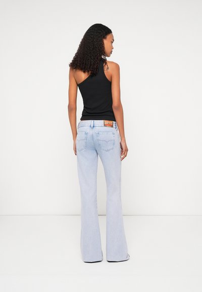 Jeans pattes d'eph bleu clair avec une taille moyenne, dotés d'un design classique à cinq poches et d'un patch en cuir marqué au dos de la ceinture.
