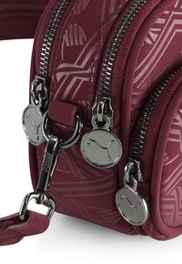 Bordeauxfarbige Handtasche mit geprägten Mustern, doppelten Reißverschlüssen und silberfarbenen Beschlägen. Verfügt über eine strukturierte Oberfläche und einen abnehmbaren Schulterriemen.
