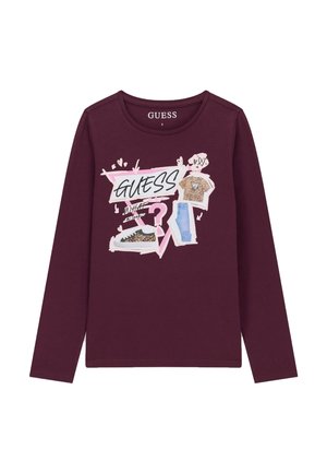 Camiseta burdeos de manga larga con gráfico en rosa y blanco de una camiseta con estampado de leopardo, vaqueros, zapatillas y la palabra "GUESS" en letras negritas.