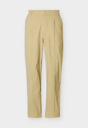 Beige maßgeschneiderte Hose mit Bügelfalten vorne, Seitentaschen und tailliertem Bund, auf einem schlichten hellen Hintergrund präsentiert.