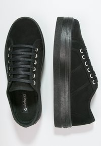 Sneakers platform in suede nera con puntale rotondo, design con lacci, occhielli argentati e suola in gomma nera texturizzata.