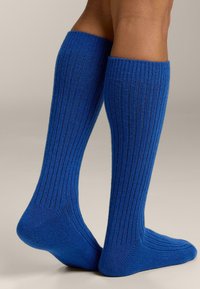 Calzini blu a coste lunghezza al ginocchio, realizzati in tessuto strutturato, che mostrano una vestibilità aderente con tallone e punta rinforzati per una maggiore durata.