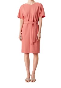 Robe corail à manches courtes, taille ceinturée, encolure en V, longueur au genou. Confectionnée dans un tissu lisse, avec un design épuré et minimaliste.