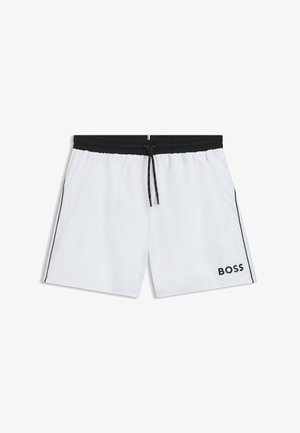 Fehér fürdőnadrág könnyű anyagból; elasztikus derékrész fekete húzózsinórral; oldalzsebek; fekete logóval és oldalsávokkal díszítve.