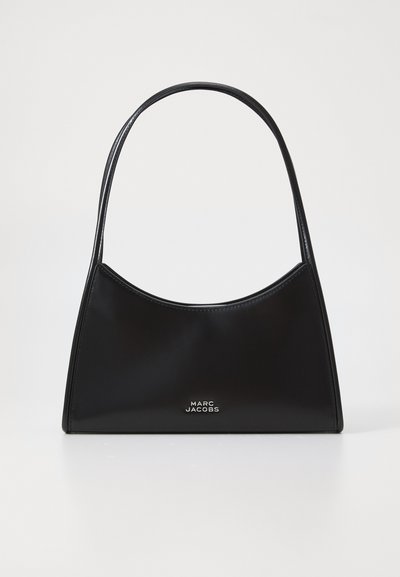 Sac à main noir au design courbé, en cuir brillant. Il dispose d'une seule poignée fine et d'un logo argenté sur le devant en bas.