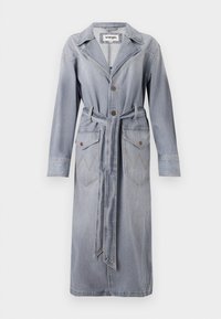 Manteau en denim bleu clair avec col, fermeture à boutons, ceinture à la taille et deux poches avant ornées de motifs de couture en zigzag.