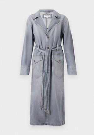 Manteau en denim bleu clair avec col, fermeture à boutons, ceinture à la taille et deux poches avant ornées de motifs de couture en zigzag.