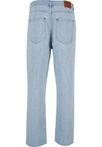 Jeans din denim de un albastru deschis, cu broderie în formă de flacără realizată cu fire deschise pe spate. Dispune de două buzunare la spate și etichetă din piele la talie.