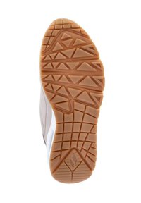 Suela de zapato con una banda de rodadura de goma color tostado que presenta patrones geométricos y un logo en forma de hoja cerca del talón.