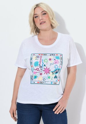 Blonde vrouw die een wit T-shirt draagt met kleurrijke zomer-geïnspireerde krabbels, waaronder sterren, schelpen, vissen en de woorden "Vacation" en "Aloha."