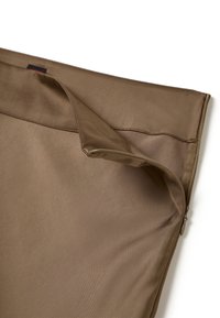 Pochette en tissu marron avec une texture lisse, dotée d'une fermeture éclair sur un côté et d'un rabat plié pour y accéder.