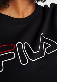 Felpa nera con scollatura tonda che presenta un design del logo bianco e rosso, significativo per la sua forma grafica audace contro il tessuto.