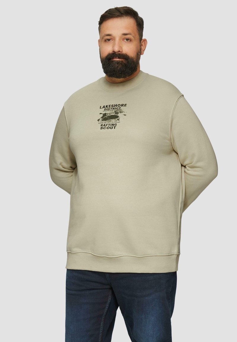 Sweatshirt beige avec col rond, manches longues, et une impression graphique portant le texte « LAKESHORE DISTRICT RAFTING SCOUT » sur le devant.
