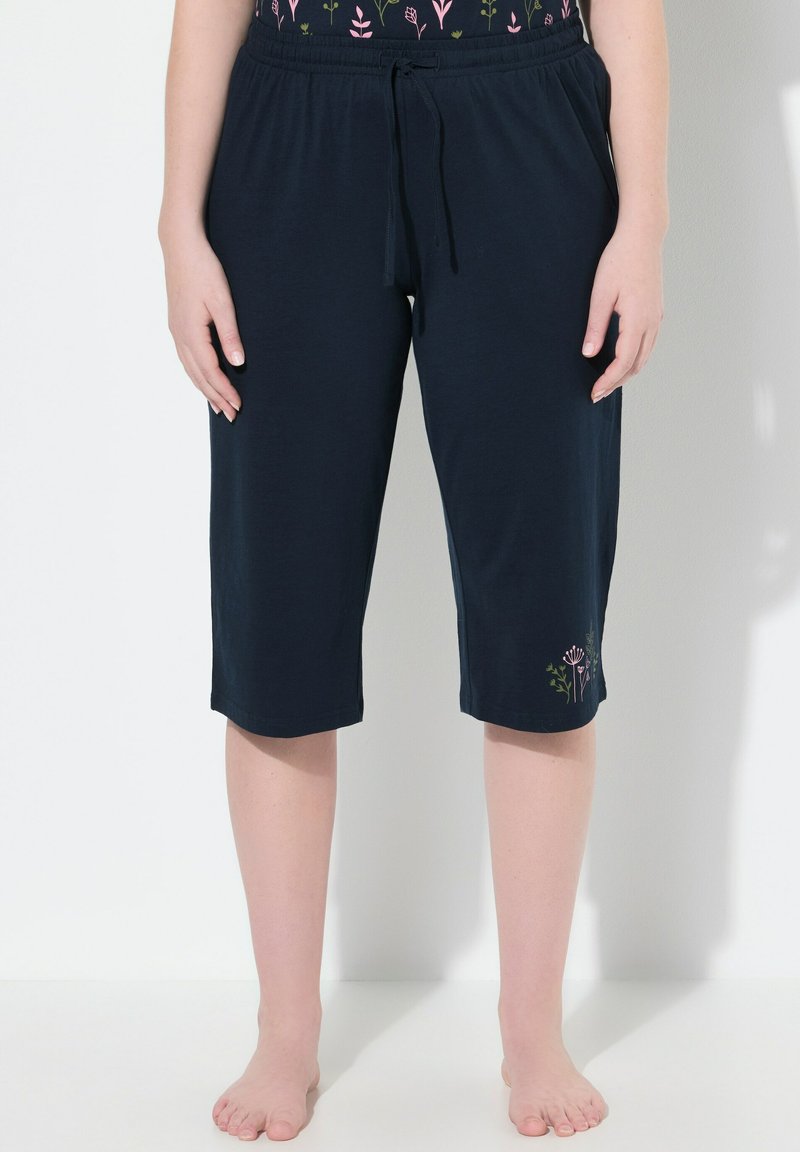 Marineblauwe capri-broeken van zachte stof met een elastische tailleband. Voorzien van bloemgeborduurde details in roze en groen op het linkerbeen.