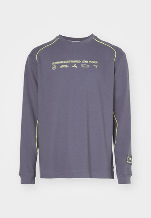 Long-sleeve shirt in dark blue with a textured pattern, featuring neon yellow accents and logos on the chest. Cotton blend material.