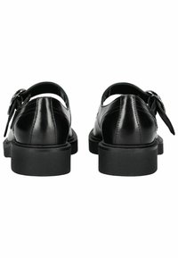 Scarpe in pelle nera con design a intaglio, fissate da una fibbia laterale. Presentano una suola nera spessa e una finitura liscia e lucida.
