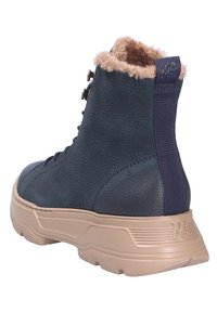 Botte montante en cuir bleu marine avec semelle en caoutchouc beige, doublure en fausse fourrure, œillets pour lacets et languette en tissu à l'arrière.