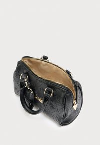 Μαύρη υφασμάτινη τσάντα με χρυσά μεταλλικά στοιχεία, κλείσιμο με φερμουάρ, διπλές χειρολαβές και μπεζ επένδυση εσωτερικά. Συμπαγές, στρογγυλεμένο σχήμα με ανάγλυφο σχέδιο.