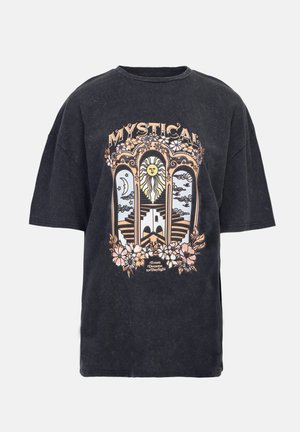 Svart oversized t-shirt med en grafik i vintage-stil som har en lejon, måne och blommor. Trycket inkluderar texten "MYSTICAL" i guld- och persikolika nyanser.