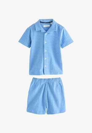 Kort-ärmige blauwe knoopshirt met een gemusterde structuur en bijpassende shorts met elastische tailleband, beide in een lichtblauwe stof.