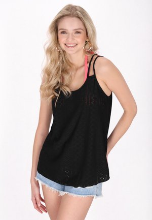Schwarzes ärmelloses Oberteil mit gemustertem Textur und rosa Trägern, kombiniert mit hellen Jeansshorts mit ausgefransten Kanten.