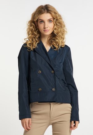 Een marineblauwe dubbelbreasted jas van lichtgewicht stof, met grote knopen en een shawl-kragen, voorzien van een getailleerde silhouette en een gladde textuur.