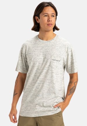 Camiseta de manga corta gris claro con un sutil patrón jaspeado, cuello redondo y un bolsillo en el pecho con un logotipo. Textura de tela suave.