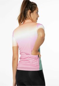 Krátký rukáv sportovní tričko s gradientem od růžové po mátově zelenou. Obsahuje prodyšnou látku a zadní kapsu na úschovu.