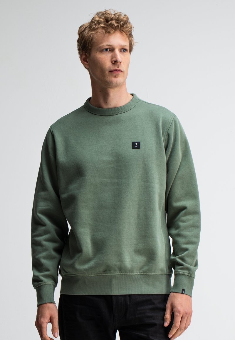 Groene crew neck sweatshirt van zachte stof, met een klein zwart logo op de borst en geribbelde manchetten en zoom.