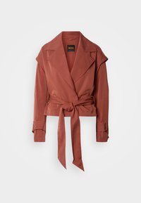 Μπουφάν σε σκουριά απόχρωση με ζώνη, φαρδιές πέτες, μακριά μανίκια με λουράκια στις μανσέτες και άνετη εφαρμογή κρεμασμένο μπροστά σε λευκό φόντο.